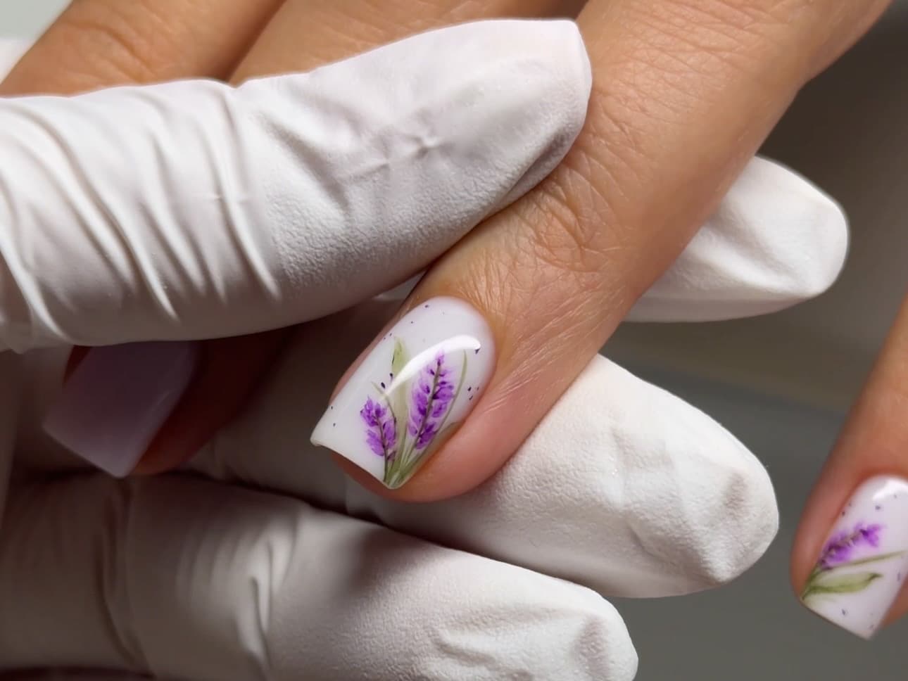 White base manicure with hand-painted lavender floral accent nails
