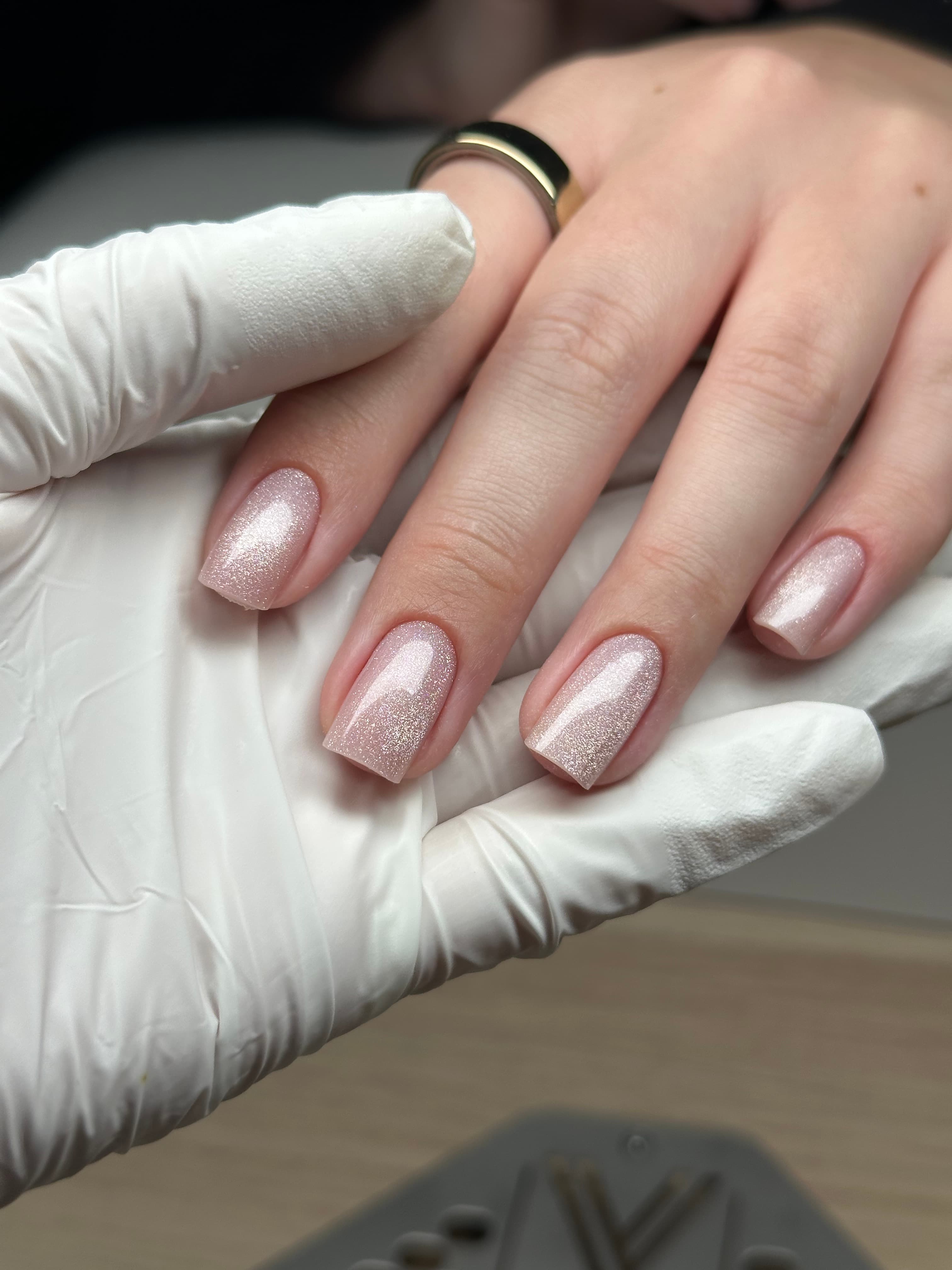Short square nails in a shimmering rose gold glitter gel polish with an ombre finish